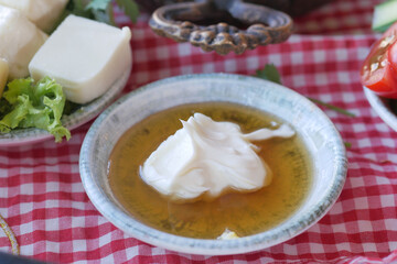 butter cream and honey in a bowl on table .