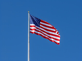 Obraz premium American flag waving proudly against a blue sky with stars and stripes, symbolizing freedom and patriotism in the United States