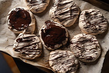 Freshly baked home merengues with chocolate topping,  on paper, on pan, french dessert, food blogging concept