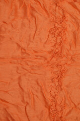 Orange crumpled textile background.