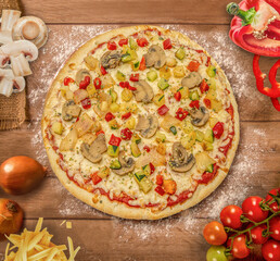 Tasty marguerita pizza and cooking ingredients tomatoes basil on wood background. Top view of marguerita pizza