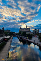 Obraz premium View of Canada parliament building in Ottawa during sunset. This photo is taken from MacKenzie King bridge above Rideau canal.
