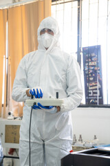 Fototapeta premium Professional Heavy Industry Robotics Engineer Wearing White Coat Holding Tablet Computer Works in Laboratory. Facility Full of Computers, control robot.