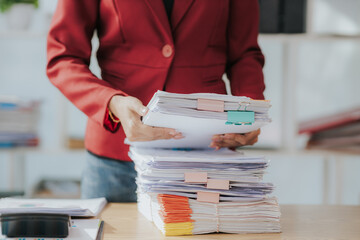 Woman's hands working in stacks of paper files to find and check unfinished documents, success in document folders at busy office Business document concept - obrazy, fototapety, plakaty