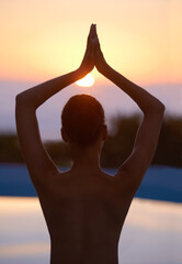 Tree, yoga and woman meditate at sunset by swimming pool for healthy body, wellness and zen outdoor. Rear view, vrikshasana pose and person at water at twilight to relax, peace or calm for balance - obrazy, fototapety, plakaty