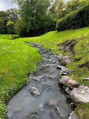 Fototapeta na wymiar River Water Flowing Over Rocks. Small Creek. Centered