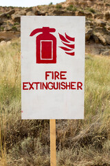 Red Fire sign extinguisher with nature in the background