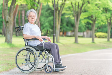 Fototapeta na wymiar 公園で車椅子に乗る高齢者女性(散歩・外出) 