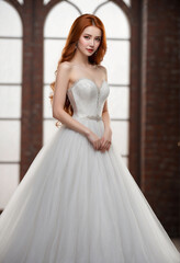 Fototapeta premium Piękna kobieta z długimi, rudymi włosami ubrana jest w piękną białą suknię ślubną.