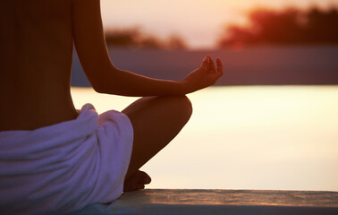 Back, yoga and hands meditate at sunset by swimming pool for healthy body, wellness and zen outdoor...