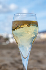 Pouring a glass of champagne on vacation, south of Fuerteventura, Canary islands, blue ocean, mountains
