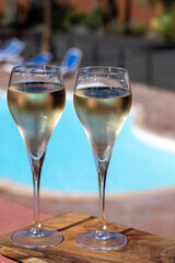 Pouring a glass of champagne on vacation, south of Fuerteventura, Canary islands, blue ocean, mountains