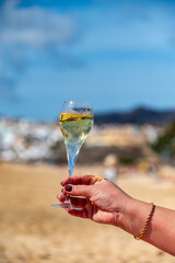 Pouring a glass of champagne on vacation, south of Fuerteventura, Canary islands, blue ocean, mountains