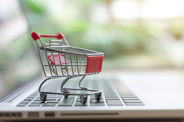 Online shopping and electronic commerce concept. Shopping cart on laptop keyboard.