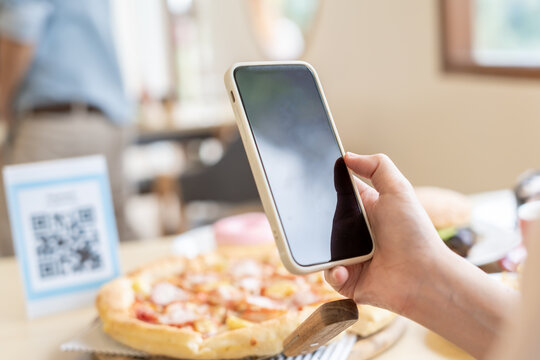 Woman use smartphone to scan QR code to pay in cafe restaurant with a digital payment without cash. Choose menu and order accumulate discount. E wallet, technology, pay online, credit card, bank app.