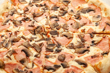 close-up of italian pizza with sausage and mushrooms on the festive table during a party