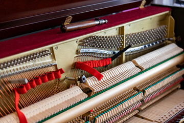 Shallow focus close-up of tools for tuning the internal mechanisms of an upright piano. Gives a...