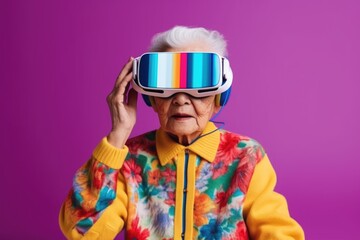 Elderly asian woman wearing virtual reality glasses over purple background