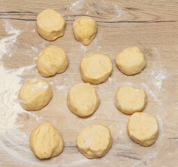 Pieces of dough on the table in flour.
