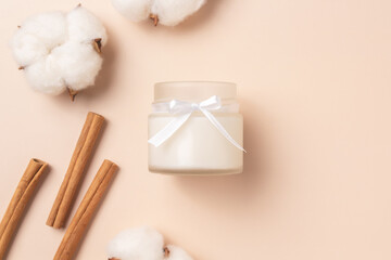 Aroma candle with the aroma of spices. Winter scents. Cinnamon sticks, cotton flowers.