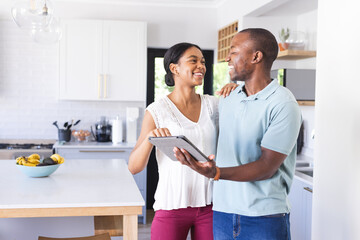 Biracial woman and African American man share a moment in the kitchen
