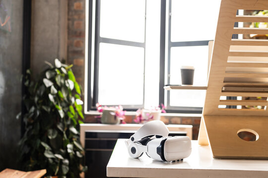 A VR headset rests on a modern desk at home, with copy space