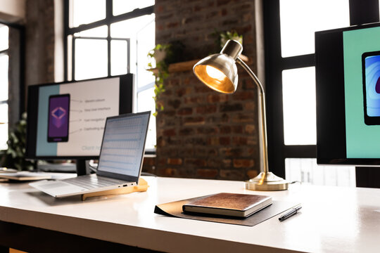 A modern casual business office setup features a laptop and desktop monitor