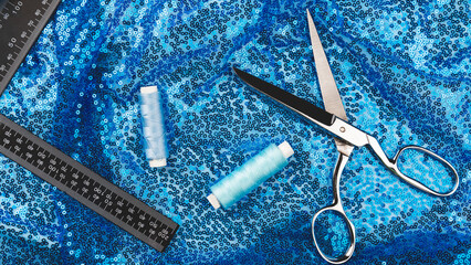 Tailoring accessories. White satin or silk fabric pattern, with blue sequins fabric, scissors, tape...