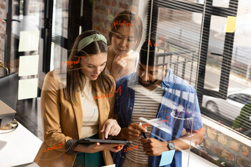 Young Caucasian woman collaborates with an Asian couple in a casual business setting in an office