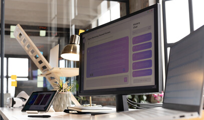 A modern casual business office setup features a computer monitor displaying a user interface
