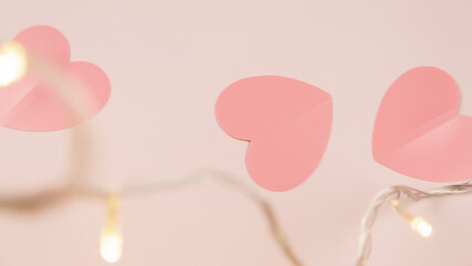 Top view of table decoration concept for Valentine's Day background. Paper cut hearts on a beautiful pink background. Several objects on pink wallpaper. Pastel tone.