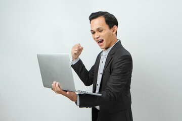 Happy asian indonesian business man in suit holding laptop computer on isolated background