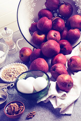 Home baking ingredients: oats, flour, walnuts, eggs, apples, and salt. Vintage toned photo. Concept of simple healthy eating.