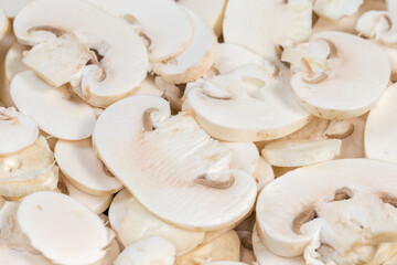 Raw sliced button mushrooms, close-up in selective focus