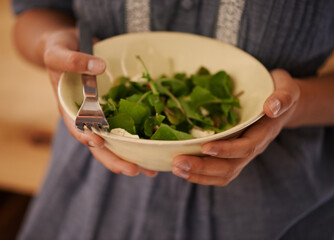 Hands, salad bowl and lettuce for healthy nutrition with vegetables in kitchen or recipe, wellness or hungry. Person, fingers and fork for organic eating or leafy greens for ingredients, dish or meal
