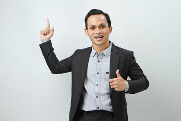 Happy confident asian indonesian business man in suit with pointing finger gesture on isolated background