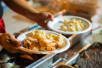 person holding a bowl of potatoes and calamari, fish food, sea