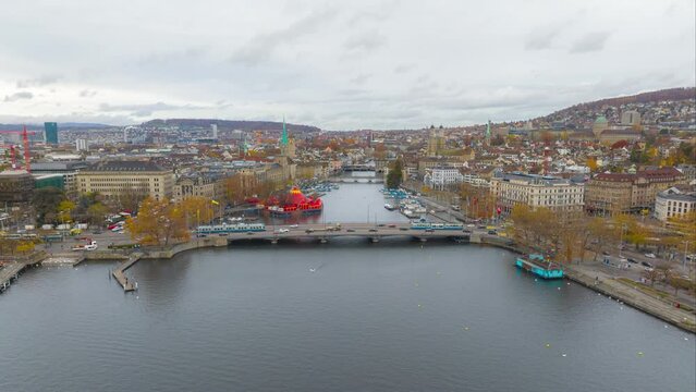 Aerial footage Hyper lapse of the Zurich old town where the Limmat river joins lake Zurich with tramway running on a bridge in Switzerland largest city. aerial view drone of Zurich city.