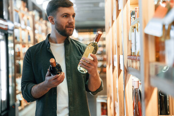 Man is choosing wine in the store