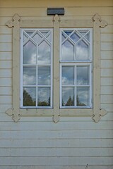 An old wooden window on a yellow painted wall.