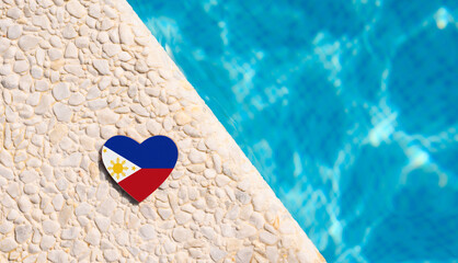 Philippines flag in the shape of a heart near the pool in the hotel. Holiday concept in hotels
