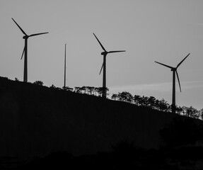 wind turbine on hill slope among the trees