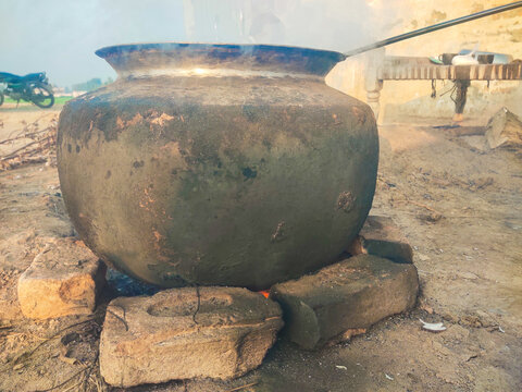 pots in the city, Side view of a Pakistani cook cooking a sweet dish (Zarda) in a pot.