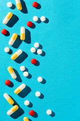Medicine, tablets, pills and capsules on blue background