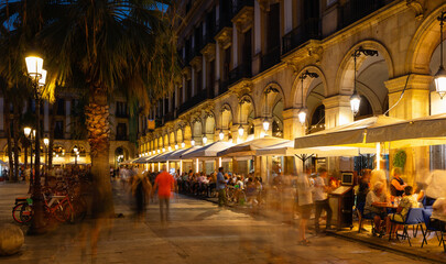 Fototapeta premium Visitors at bars and restaurants at Placa Reial - square in Barri Gotic of Spanish Barcelona