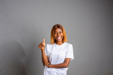 excited young lady doing thumps up in an isolated background