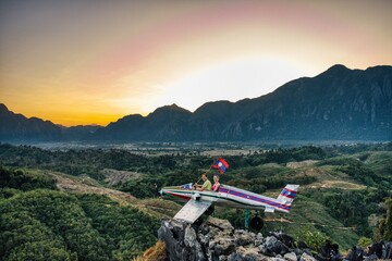 Sunrise in Vang Vieng at Phapoungkham viewpoint. Airplane on the top of the mountain, Sunset time,...