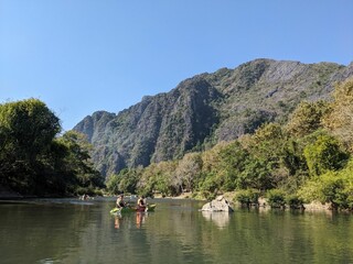Fototapeta na wymiar Nam Song River at Vang Vieng Laos. Beautiful kayak trip on the river nextto huge mountains and beautiful nature. Holday time