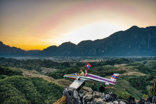 Sunrise in Vang Vieng at Phapoungkham viewpoint. Airplane on the top of the mountain, Sunset time, sun goes down, amazing view