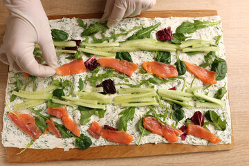 Salmon is added to the pita bread with vegetables, cheese and greens. Preparation of pita bread...